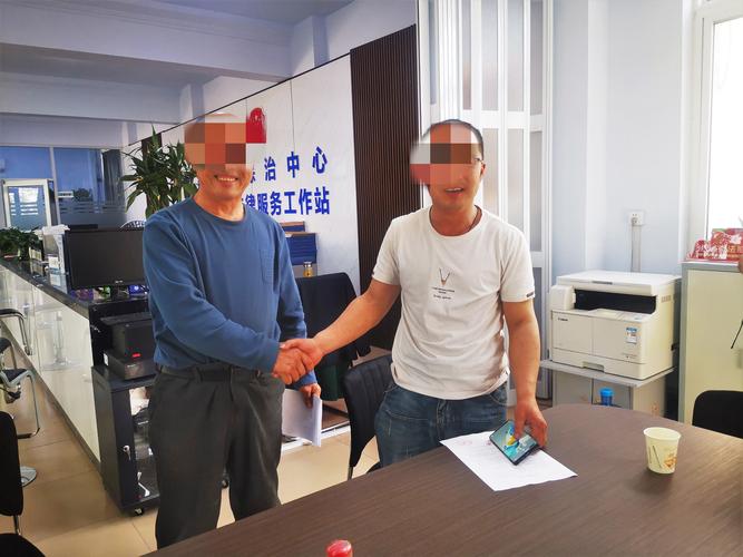 南京社区法律援助值班桌堆着的调解笔录和老人攥皱的房产证复印件