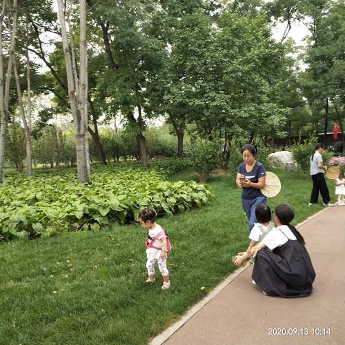 工业企业员工下班后陪孩子在园区绿地聊天图