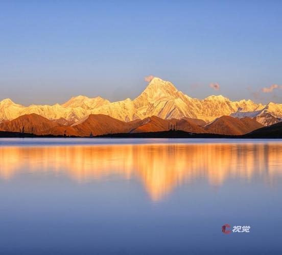 冰湖倒影中的金色雪峰