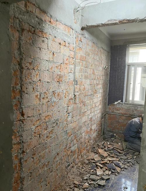装修师傅铲除旧墙皮到红砖层施工中