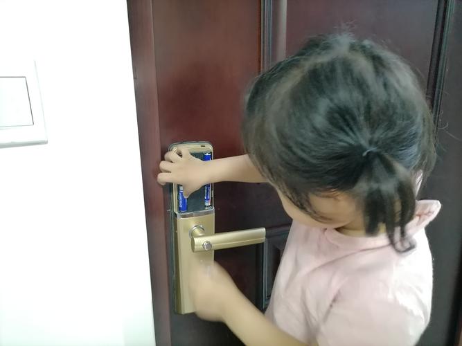 3岁幼儿踮脚按家门指纹锁的日常场景