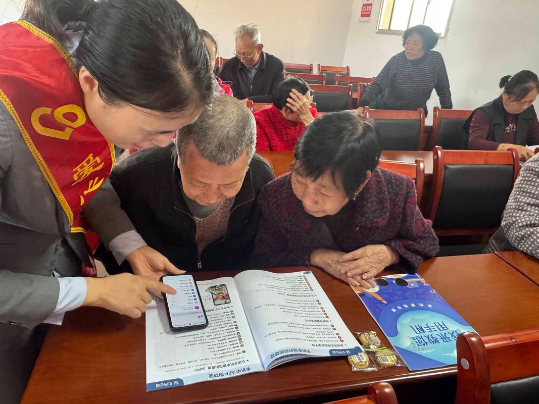 老年人在社区志愿者的指导下学习使用智能手机