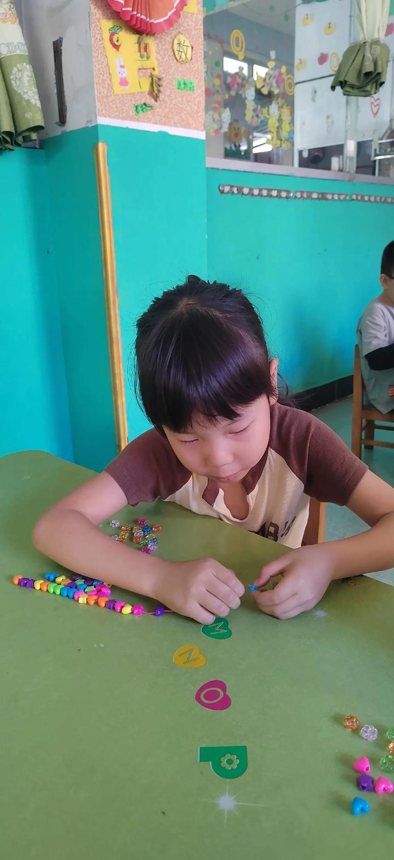 幼儿专注穿珠子游戏场景
