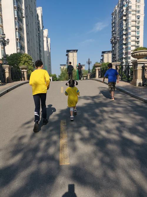 傍晚小区步道家长追娃跑步实拍