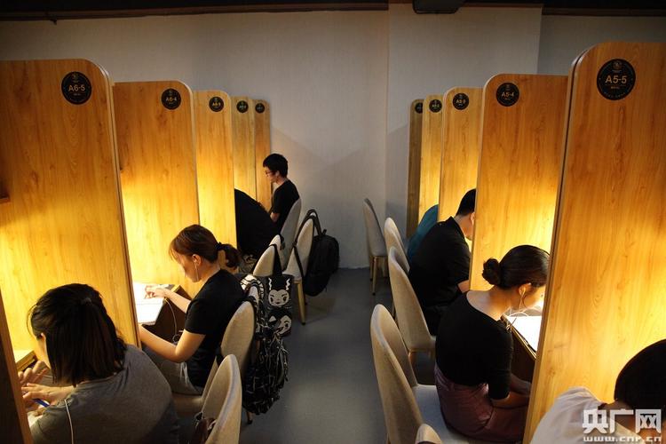 初中教室后排学生在自习课上安静读课外书的背影