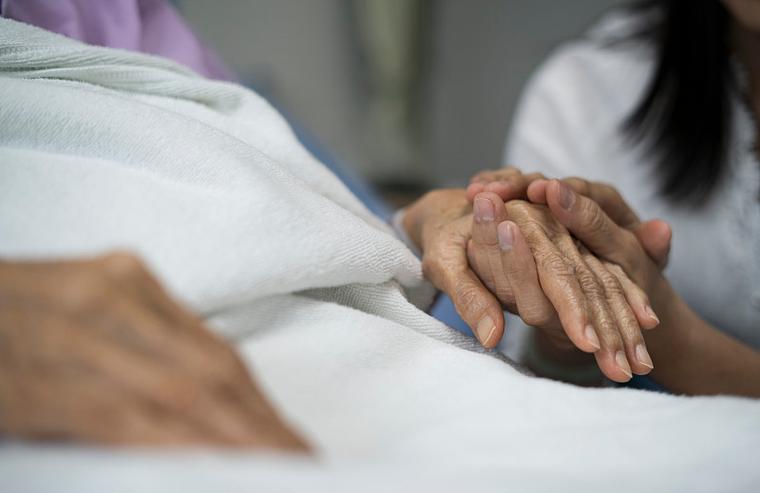 医院病床边母亲握着孩子手轻声安慰