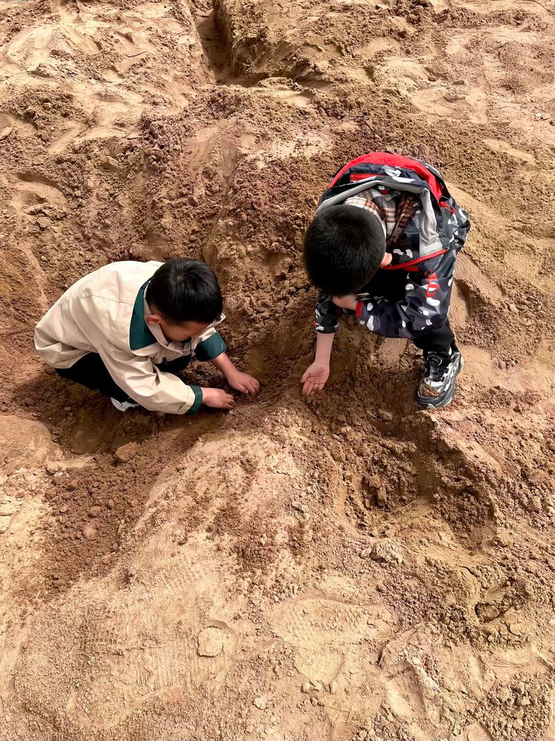 孩子专注挖沙子玩土的慢养场景
