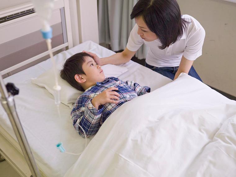 重病儿童恢复期家长牵手孩子坐床边照片