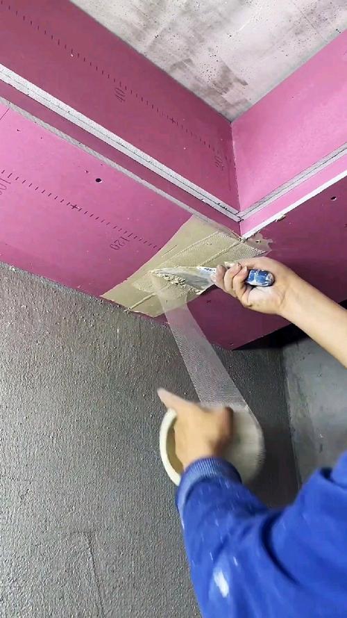 斜打手电检查石膏板防裂带的施工场景