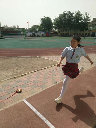 小学阳光体育跳长绳队伍边揣着橘子的女生