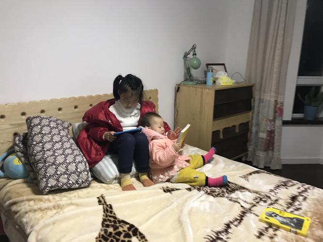 倒班妈妈靠在床上听孩子讲幼儿园趣事场景照
