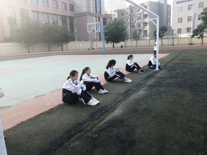 中学操场跑道边坐着休息的学生