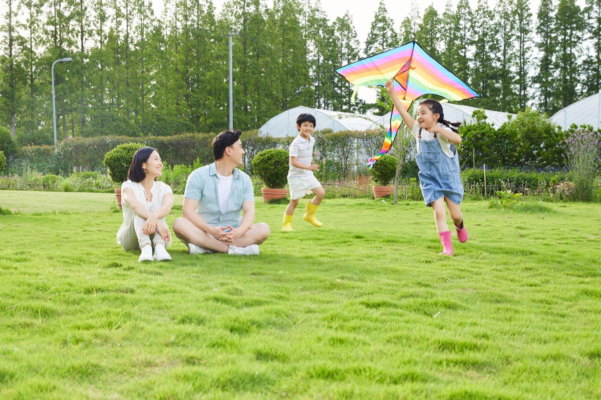 春日公园草地亲子放风筝休闲场景