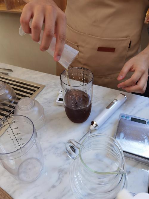 往不锈钢烧水壶中倒入食品级柠檬酸粉末的日常操作场景