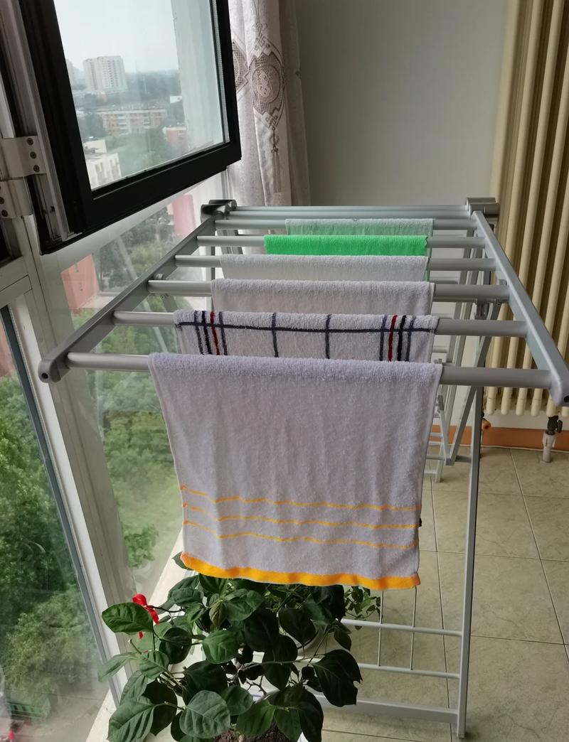 阳台伸缩晾衣杆上挂着三条干净棉毛巾