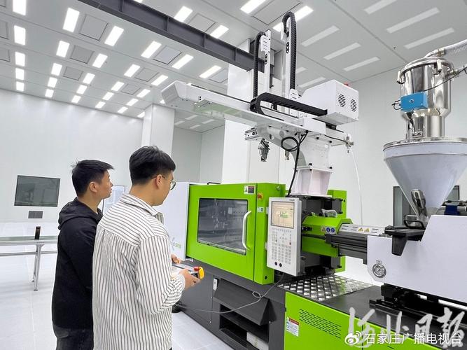 注塑机厂家调试现场，技术员正在操作控制器
