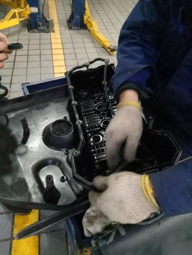 汽修师傅戴棉纱手套触摸发动机气门室盖密封胶