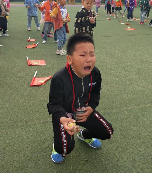 小学操场接力赛摔倒蹲在地上哭的小男孩