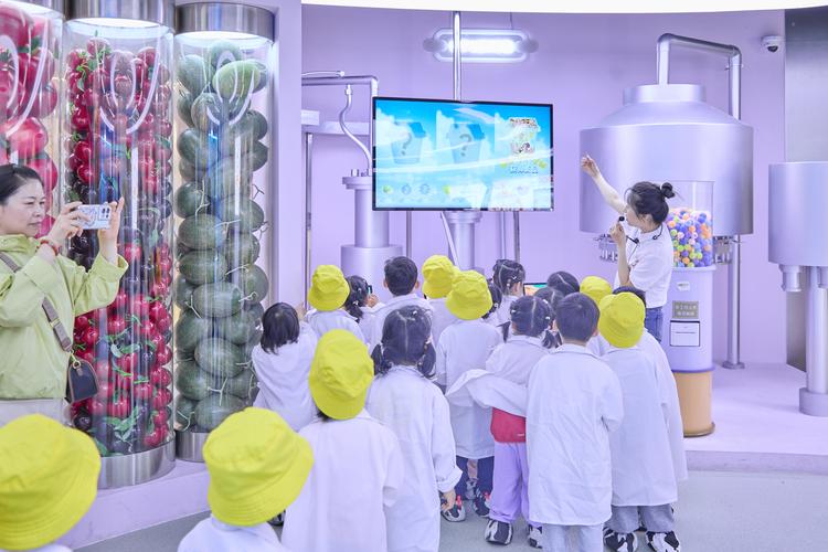 小朋友隔着玻璃看牛奶灌装生产线场景