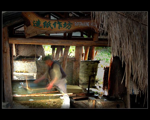 老造纸作坊廊檐下学生围坐听匠人讲往事的场景