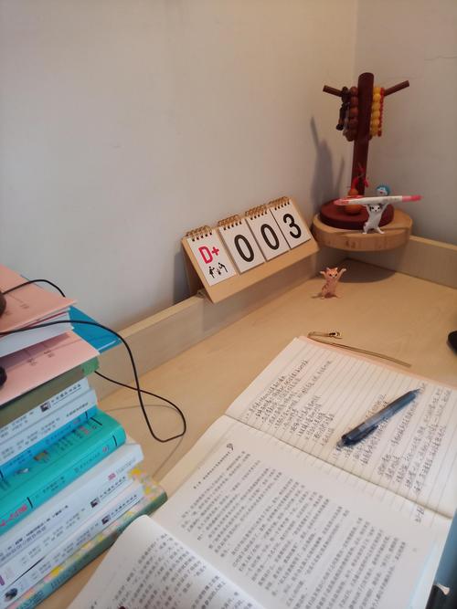 学生书桌贴满学习计划表笔记本和闹钟实拍