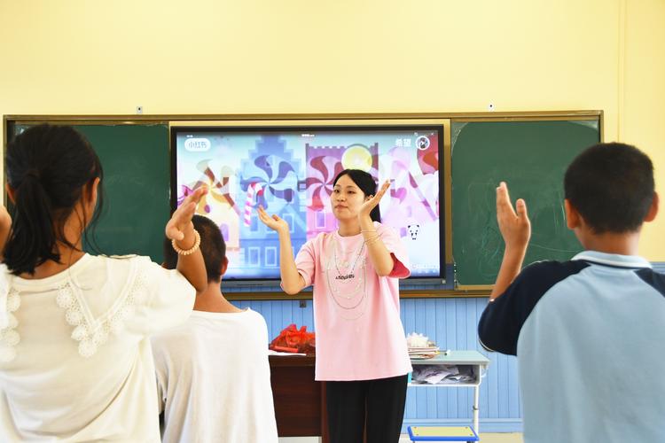 小学融合教育课堂上特教老师与普通孩子和特殊儿童互动的场景
