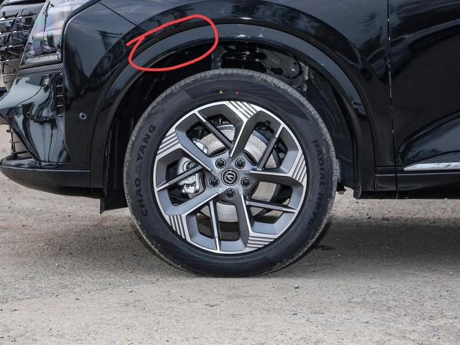 车主按压汽车前轮轮眉检查平面轴承间隙