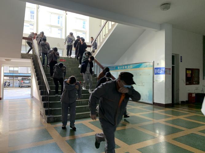 中学教学楼消防通道楼梯间 穿工装的家长蹲坐