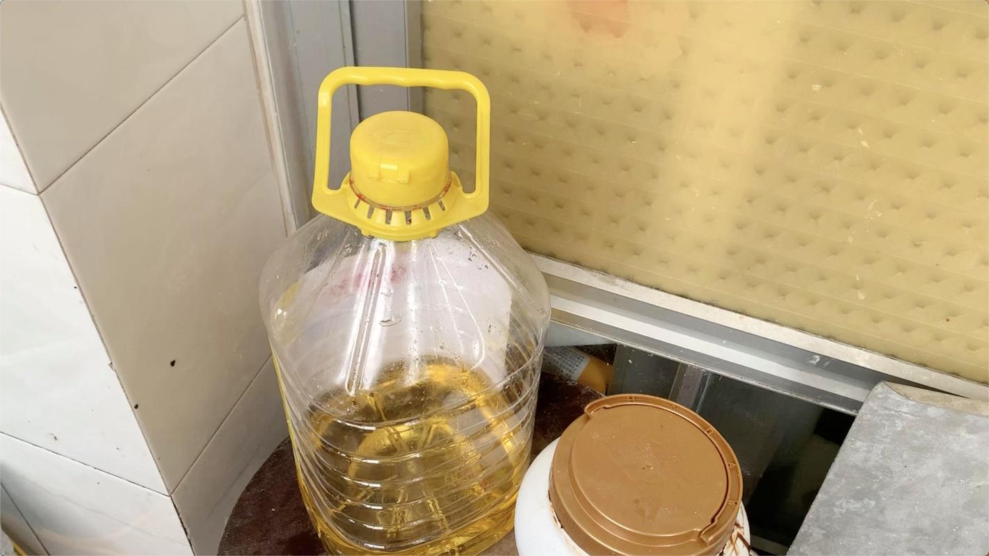 厨房灶台旁放置打开的食用油桶实拍图