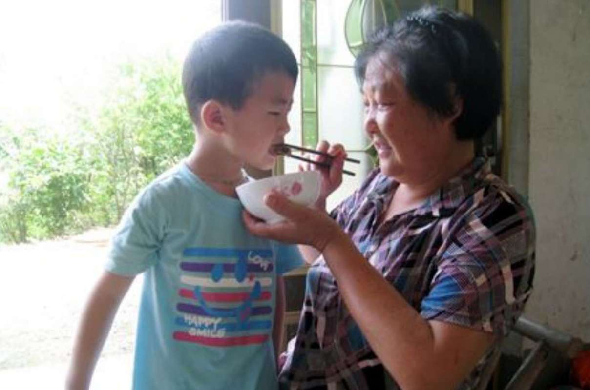 小区老人追着小孩喂饭场景图