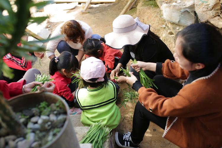 贵州黔东南侗寨少数民族家长带孩子摘野菜场景