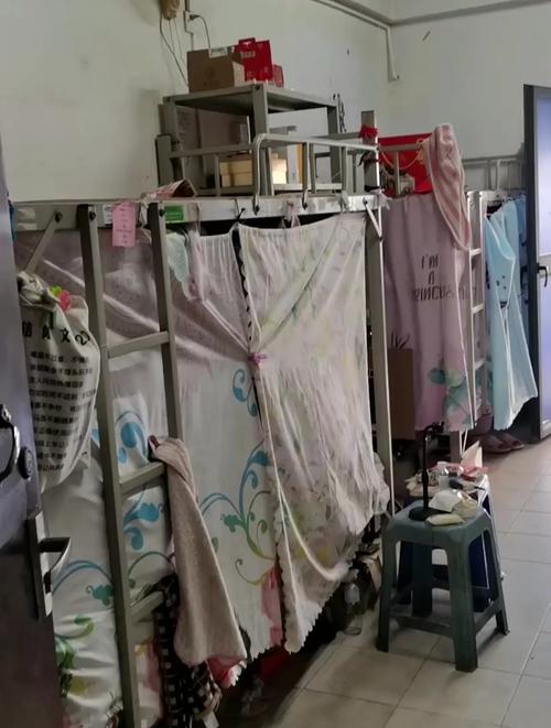 工厂宿舍工人拉遮光帘整理睡前物品图