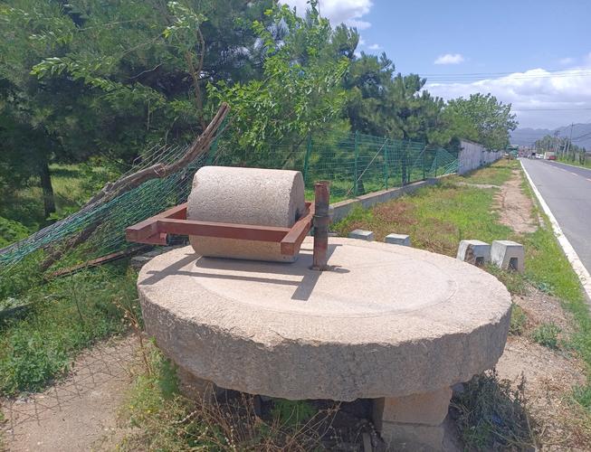 废弃石磨盘被丢弃在路边
