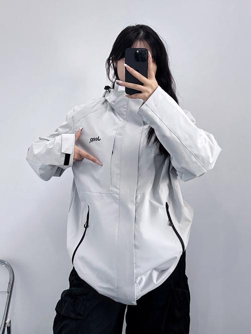 一对新人穿着冲锋衣在雨天的冰川前自拍手里提着湿透的礼服裙摆