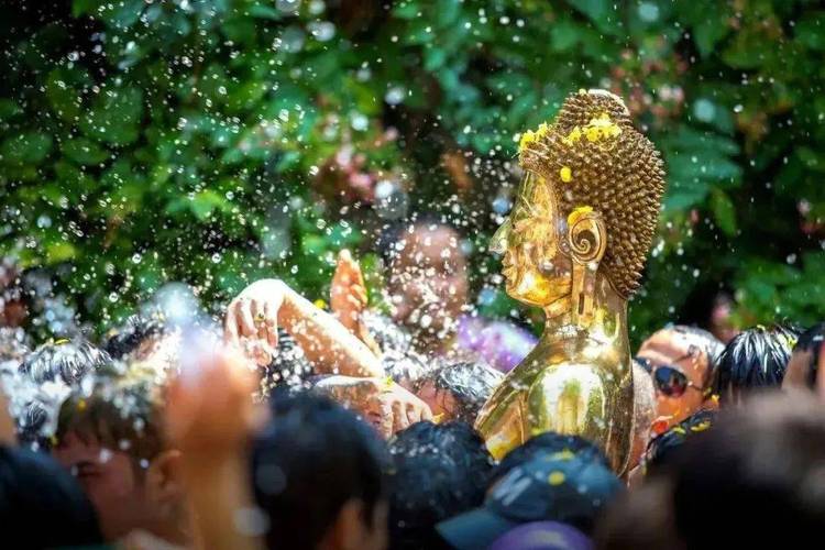 西双版纳曼听总佛寺泼水节浴佛仪式 信众排队用贝叶沾清水浇佛像