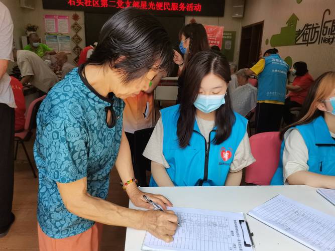 社区养老公益讲座业务员给老年人递笔签字现场图