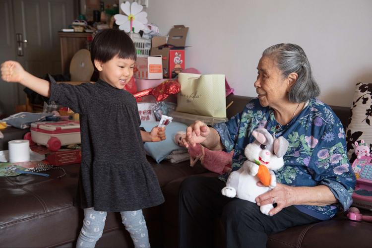 居家客厅小孩戳长辈内眼角互动场景
