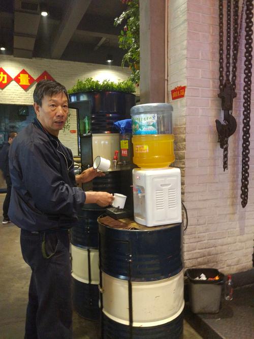 机修工清晨在厂区门口买热豆浆的实景图