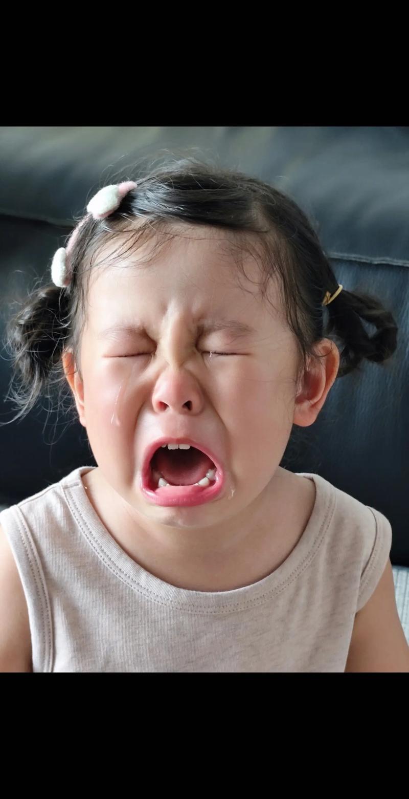 妈妈蹲下抱着哭泣的小女孩，表情温柔