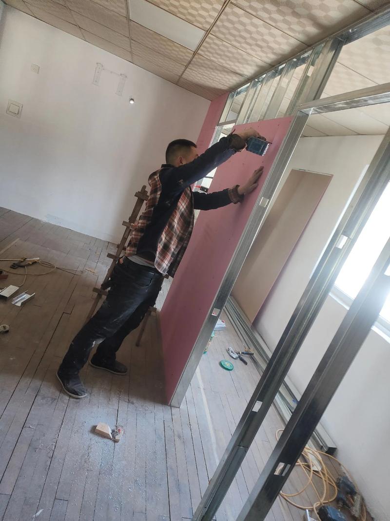 装修师傅正在安装镂空隔断的施工现场