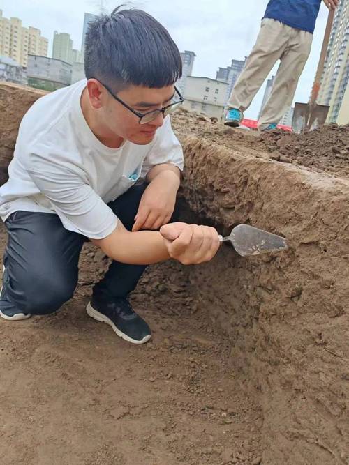文保志愿者用手铲清理考古地层实拍图