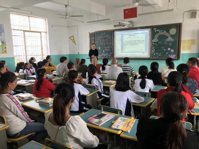初中语文公开课课堂上老师举着半块橘子和学生互动的实拍