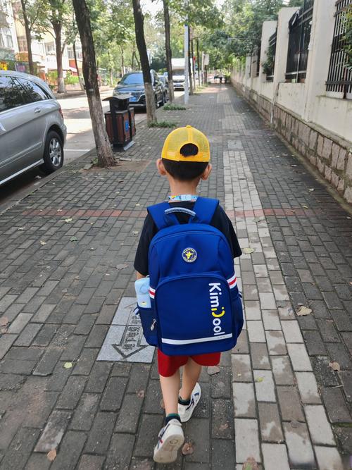 小学生背超重书包放学背影图
