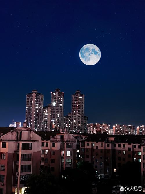 城市夜晚小区楼群间的弯月摄影