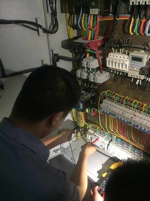 装修师傅戴着绝缘手套检查电箱内部线路