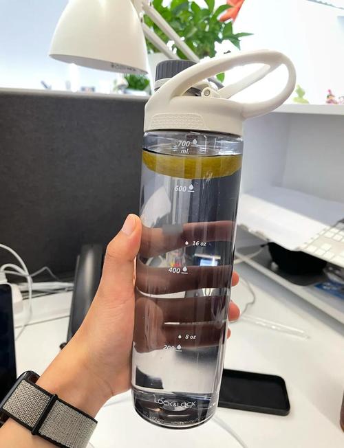 办公桌上透明大水壶和电脑并排放置