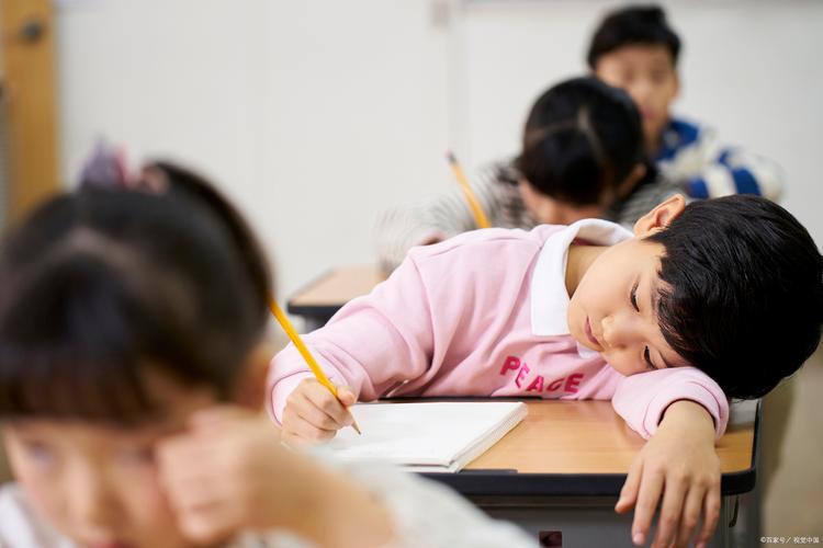 孩子疲惫地坐在课外班课堂上