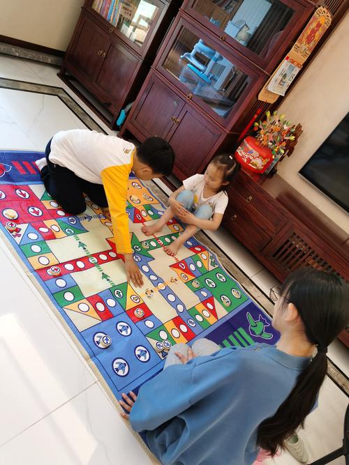 一家人围坐地毯玩飞行棋亲子互动实拍