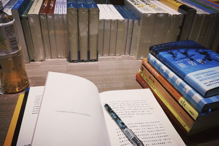 书桌摊开的推理小说和冰咖啡钢笔