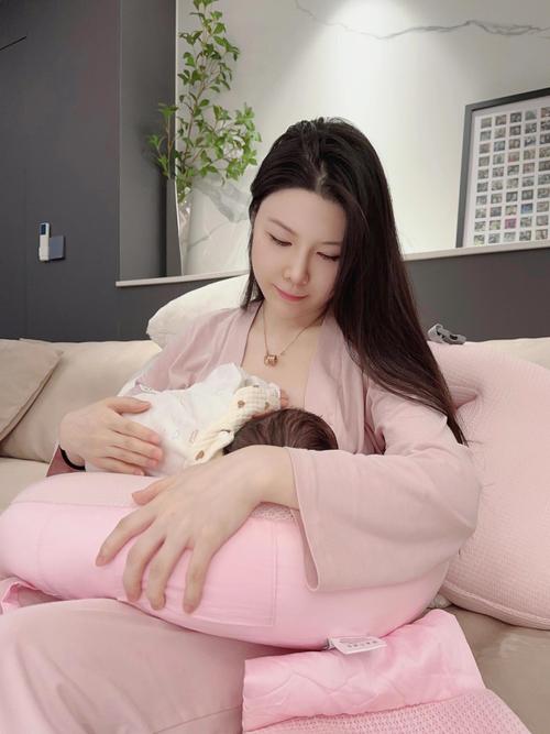 产后妈妈坐沙发喝奶茶抱娃放松照